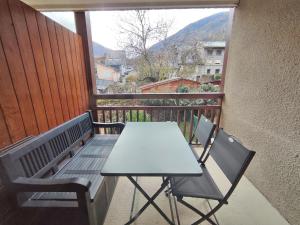 stół i krzesła na balkonie z widokiem w obiekcie Le cerf charmant, T2, Luchon, wifi, balcon, ascenseur, 4 personnes w mieście Luchon