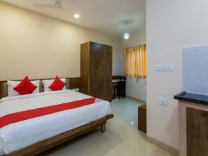 ムンバイにあるOYO Flagship 80644 Hotel Noble Palaceのベッドルーム1室(赤い枕のベッド1台、デスク付)