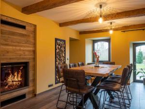 a dining room with a table and a fireplace at La Maison du Notaire - Gîte 18 personnes in Houffalize