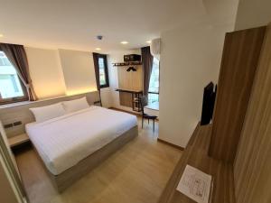a bedroom with a bed and a television in it at Thana Wisut Hotel - SHA Plus in Bangkok