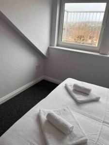 ein Schlafzimmer mit einem Bett mit zwei Handtüchern darauf in der Unterkunft Brynmill Flat in Swansea