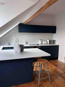 a kitchen with a sink and a counter with a stool at Brynmill Flat in Swansea