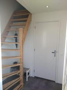 Una escalera de madera en una habitación junto a una puerta en Beachhouse ZeeZuid., en Egmond aan Zee