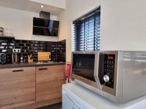 una cocina con microondas sobre una encimera en Beachhouse ZeeZuid., en Egmond aan Zee