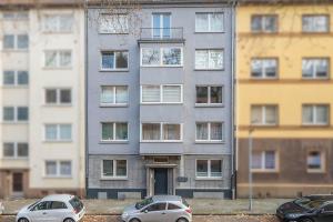 two cars parked in front of a tall building at Work & Stay Apartment in Gelsenkirchen in Gelsenkirchen