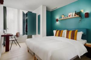1 dormitorio con cama y pared azul en Edgar Suites Vicat - Porte de Versailles, en París