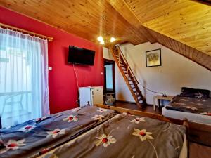 ボニャルツバシュにあるDolce Villa Balatonの赤い壁のベッドルーム1室(ベッド2台付)