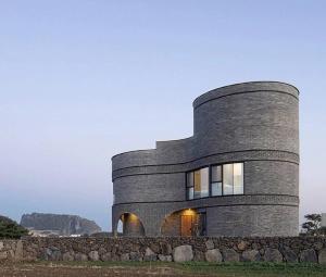 a round house with a stone wall at Luxury Pool Villa, Villecot in Seogwipo