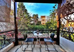 balkon ze stołem i 3 krzesłami na balkonie w obiekcie Όμορφο Κατάλυμα στην Άνω Πόλη Πάτρας w mieście Patras