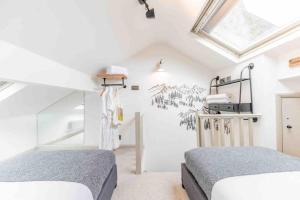 a bedroom with two beds and a skylight at Teapot Cottage in Ennerdale - Hot tub Pizza Oven Log Burner in Cleator