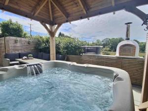 a hot tub in a backyard with a gazebo at Teapot Cottage in Ennerdale - Hot tub Pizza Oven Log Burner in Cleator