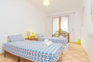 2 Betten in einem Zimmer mit blauer und weißer Bettwäsche in der Unterkunft Villa Ewa by Slow Villas in Cala Pi