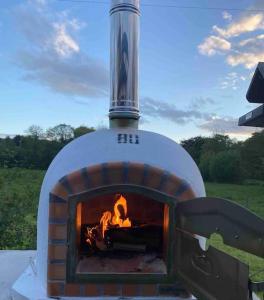 a brick oven with a fire inside of it at Teapot Cottage in Ennerdale - Hot tub Pizza Oven Log Burner in Cleator