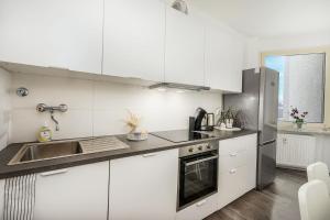a kitchen with white cabinets and a stainless steel refrigerator at work & stay in Gelsenkirchen in Gelsenkirchen