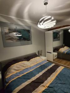 a bedroom with a large bed and a chandelier at Nadmorski Apartament in Gąski