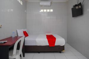 a bedroom with a bed and a desk and a television at RedDoorz near Danurejan Malioboro in Yogyakarta