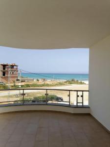um amplo quarto branco com vista para a praia em villa s+5 pied dans l'eau Plage Ezzahra 22993892 em Kelibia