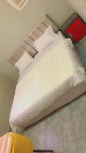 Bett mit weißer Bettwäsche und Kissen in einem Zimmer in der Unterkunft السعاده للشقق المفروشة in Medina
