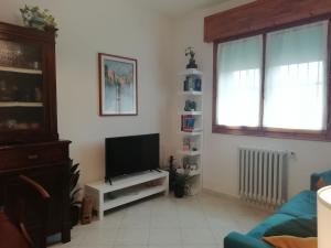 a living room with a flat screen tv and a window at Casa Bellini in Comacchio