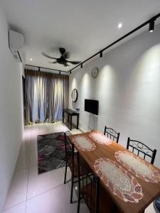 sala de estar con mesa, sillas y TV en Apartment with 2 Bedrooms, Trefoil @ Setia City (Imperia Asia Guest House), en Shah Alam