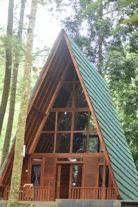 ein winziges Haus im Wald mit grünem Dach in der Unterkunft Wonderful Citamiang by Anrha in Puncak