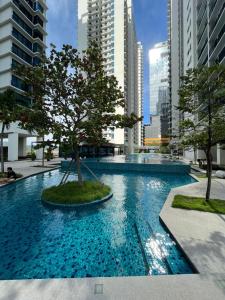 a large swimming pool with a tree in a city at Apartment with 2 Bedrooms, Trefoil @ Setia City (Imperia Asia Guest House) in Shah Alam