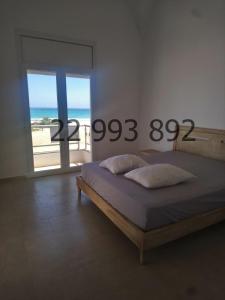 um quarto com uma cama e vista para o oceano em villa s+5 pied dans l'eau Plage Ezzahra 22993892 em Kelibia