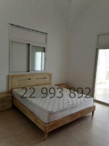 uma cama grande num quarto com um espelho em villa s+5 pied dans l'eau Plage Ezzahra 22993892 em Kelibia