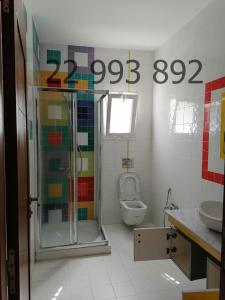 uma casa de banho com um chuveiro e um WC. em villa s+5 pied dans l'eau Plage Ezzahra 22993892 em Kelibia