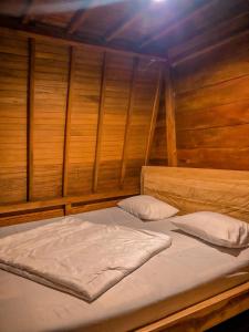 2 Betten in einem Zimmer mit Holzwänden in der Unterkunft Wonderful Citamiang by Anrha in Puncak