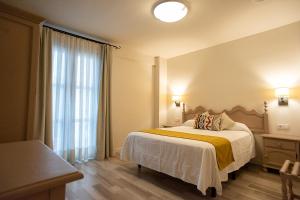 a hotel room with a bed and a window at Hotel Casa Palacio la Sal in Córdoba