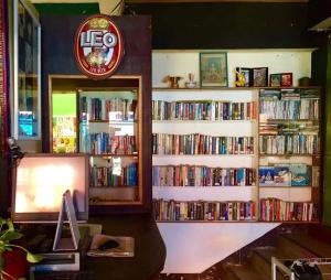 a library filled with books and a desk with a computer at Hidden Lumpu in Bangkok
