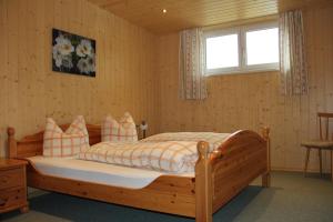 sypialnia z drewnianym łóżkiem i oknem w obiekcie Gostanova Appartements w mieście Gaschurn