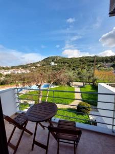 a balcony with a table and chairs and a view at Mati- Cozy apartment- Close to the beach of Almyrida with a shared Pool in Chania