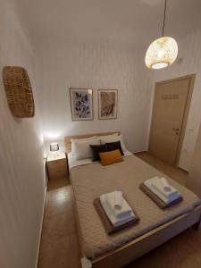 a bedroom with a bed with two towels on it at Mati- Cozy apartment- Close to the beach of Almyrida with a shared Pool in Chania