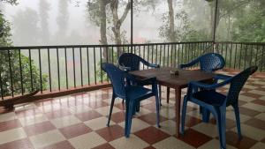 a wooden table and chairs on a balcony at Jungleview Home Stay in Idukki
