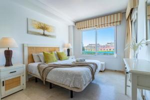 1 dormitorio con cama y ventana grande en Casa adosada familiar en complejo con piscina - Bel Air 28, en Estepona