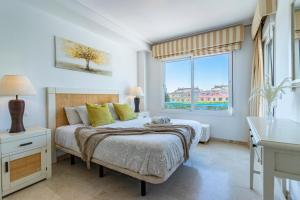 ein Schlafzimmer mit einem Bett und einem großen Fenster in der Unterkunft Casa adosada familiar en complejo con piscina - Bel Air 28 in Estepona + 49 Fotos