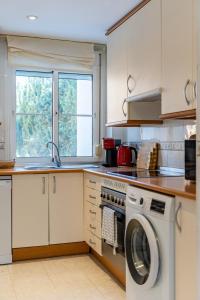 cocina con lavadora y ventana en Casa adosada familiar en complejo con piscina - Bel Air 28, en Estepona