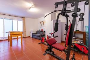 ein Wohnzimmer mit einem Fitnessraum mit einem Laufband in der Unterkunft Casa adosada familiar en complejo con piscina - Bel Air 28 in Estepona