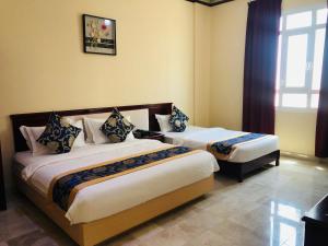 a hotel room with two beds and a window at Farah Hotel Apartment in Muscat