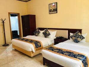 ein Hotelzimmer mit 2 Betten in einem Zimmer in der Unterkunft Farah Hotel Apartment in Muscat