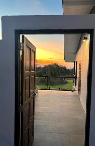 una puerta abierta con una puesta de sol en el fondo en I love phants Lodge en Ban Huai Thawai