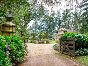 a garden with a gate and flowers and a house at Backworth House in Mid Illovo