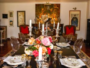 een eetkamer met een tafel met bloemen en kaarsen bij Backworth House in Mid Illovo