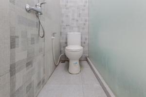 a bathroom with a toilet and a shower at RedDoorz at Ngaggel Jaya Surabaya in Surabaya