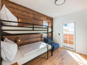 a bedroom with two bunk beds and a wooden wall at Leni`s Mountain Appartements in Dienten am Hochkönig