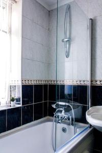 y baño con ducha, bañera y lavamanos. en Modern 4 Bed House Sleep 7, en Liverpool