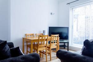 a dining room with a table and chairs and a television at Modern 4 Bed House Sleep 7 in Liverpool