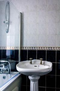 a bathroom with a sink and a bath tub at Modern 4 Bed House Sleep 7 in Liverpool